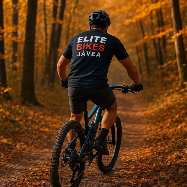Mountain biker wearing Elite Bikes Javea shirt riding through an autumn forest on the Costa Blanca